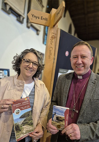 Two people holding Llwybr Cadfan Passport
