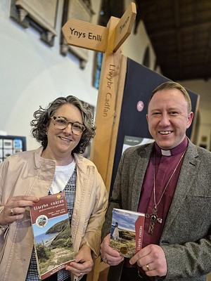 Two people holding Llwybr Cadfan Passport